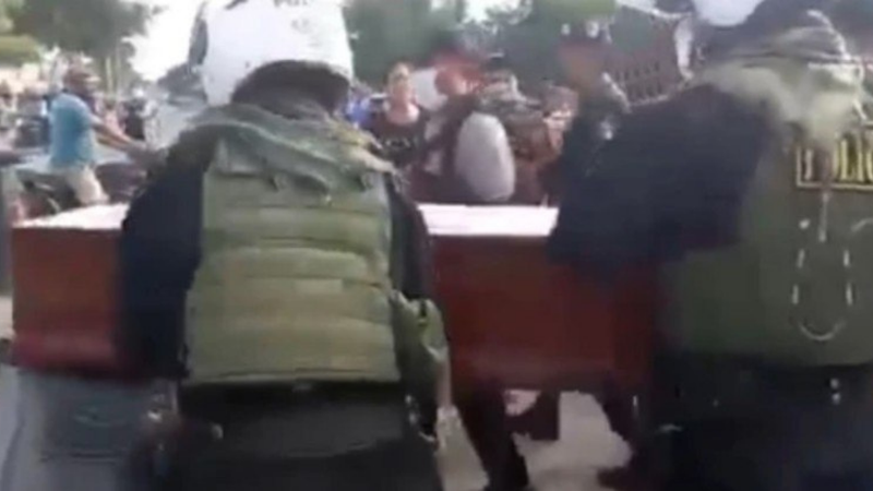 Policiais socorrem mulher em caixão