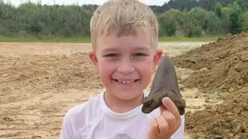 O pequeno Riley segurando dente de tubarão - Divulgação / Palmetto Fossil Excursions