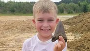 O pequeno Riley segurando dente de tubarão - Divulgação / Palmetto Fossil Excursions