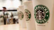 Na imagem, copos do Starbucks dispostos sobre mesa - Getty Images