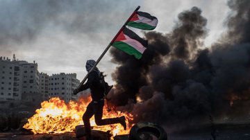 Homem segura bandeira da palestina durante protesto em Jerusalém - Getty Images