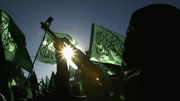 Integrantes do Hamas seguram armas e bandeiras - Getty Images