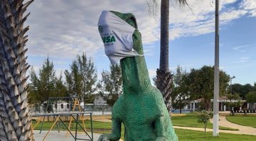 Foto de uma estátua de dinossauro com máscara - Divulgação/Twitter