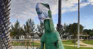 Foto de uma estátua de dinossauro com máscara - Divulgação/Twitter
