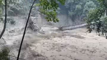 Imagem mostrando ponte derrubada pela água - Divulgação/YouTube/The Guardian