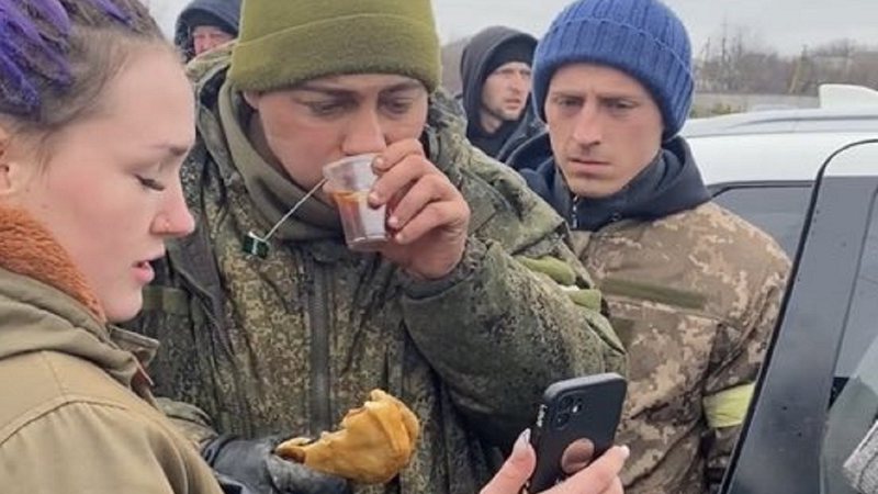 Civis ucranianos alimentando soldado russo