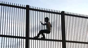 Criança escalando o muro que separa os Estados Unidos do México - Wikimedia Commons