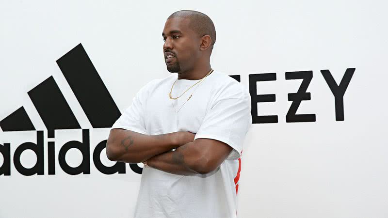 Kanye West com imagem da Adidas ao fundo - Getty Images