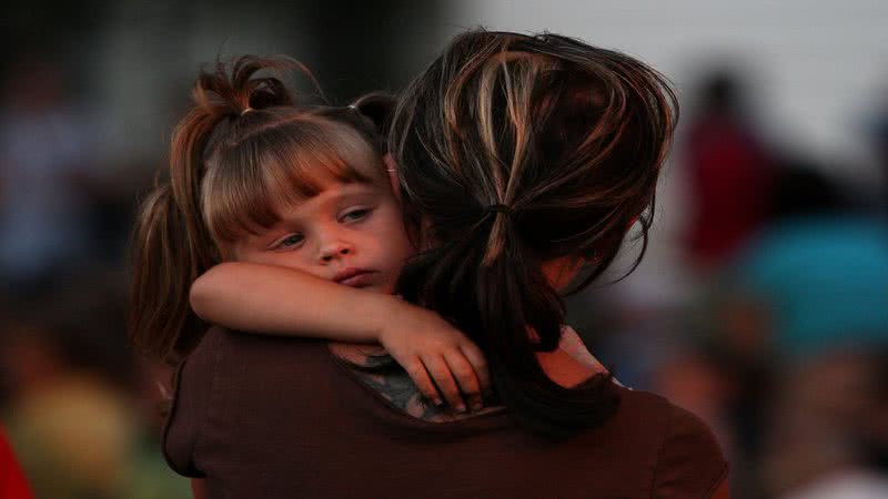 Mulher segurando no colo sua filha - Getty Images