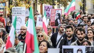 Manifestantes, alguns segurando faixas com a imagem de Mahsa Amini, protestam em Berlim, Alemanha, contra o regime do Irã - Getty Images