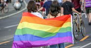 Mulheres com a bandeira LGBTQ+ em passeata - Getty Images