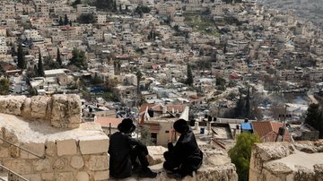 Imagem ilustrativa de homens observando um bairro localizado em Jerusalém Oriental - Getty Images