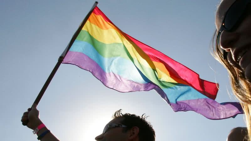 Imagem meramente ilustrativa de bandeira LGBT sendo levantada