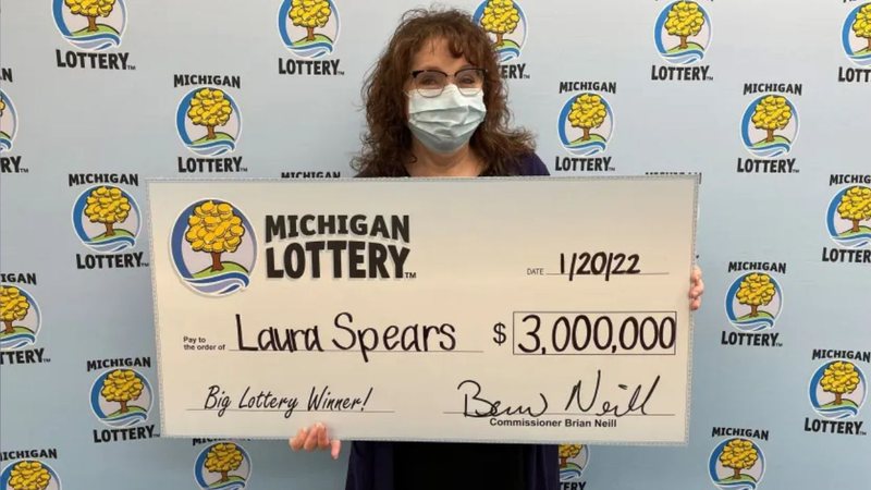 Laura segurando cheque ilustrativo com prêmio - Divulgação / Michigan Lottery