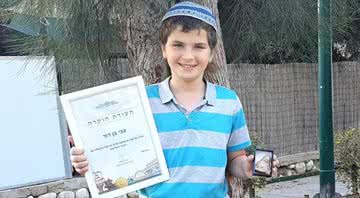 Fotografia do menino de 11 anos segurando a estátua que encontrou - Divulgação/Autoridade de Antiguidades de Israel