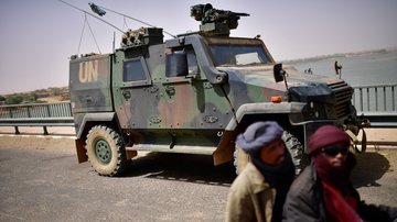 Homens passam por um tanque das Forças Armadas Alemãs, no Níger, usado para combater grupos terroristas locais - Getty Images