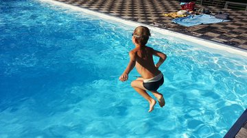 Foto ilustrativa de criança pulando em piscina - Divulgação/g. p,/Pixabay