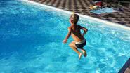 Foto ilustrativa de criança pulando em piscina - Divulgação/g. p,/Pixabay