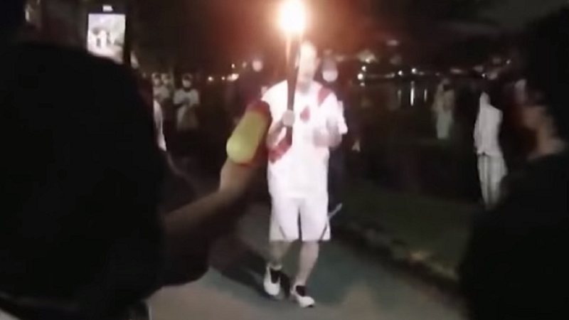 Momento em que manifestante tenta apagar a tocha - Divulgação/YouTube/South China Morning Post