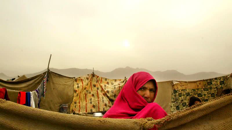 mulher afegã fora de sua casa em 2004 no campo de refugiados Babrak Garden em Cabul, Afeganistão. - Getty Images