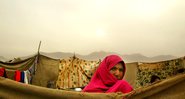 mulher afegã fora de sua casa em 2004 no campo de refugiados Babrak Garden em Cabul, Afeganistão. - Getty Images