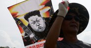 Manifestante carregando um cartaz representando Kim Jong-un, Líder Supremo da Coreia do Norte - Getty Images