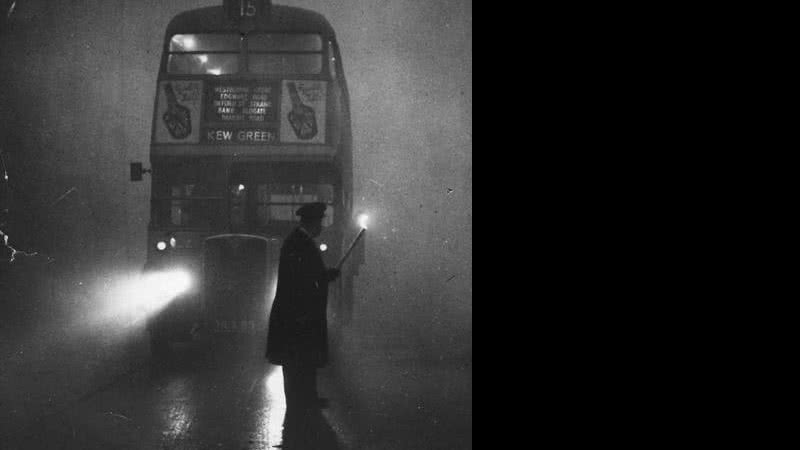 Homem usa uma tocha para guiar um ônibus durante o Grande Nevoeiro de 1952 - Monty Fresco/ Getty Images