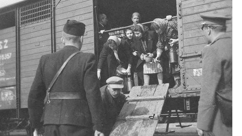 Guarda nazista força judeus a entrarem em um dos trens, em 1942 - Wikimedia Commons