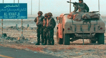 Soldados americanos ao lado da placa de Khafji, Guerra do Golfo.  - Wikimedia Commons