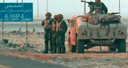 Soldados americanos ao lado da placa de Khafji, Guerra do Golfo.  - Wikimedia Commons