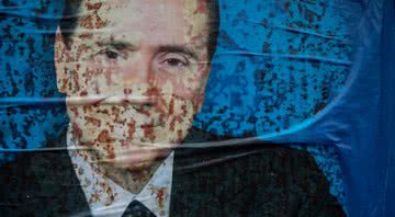 Foto do ex-premiê Silvio Berlusconi colada em um muro - Getty Images