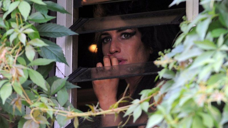 Amy Winehouse na janela de sua residência - Getty Images