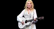 Dolly Parton com violão durante apresentação em 2014 - Getty Images