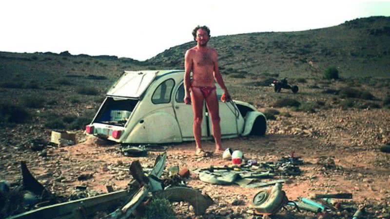 Fotografia dele no deserto, perto de carro desmontado - Divulgação/ Emile Leray