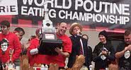 Joey Chestnut erguendo o troféu no Campeonato Mundial de Alimentação, em 2012 - Wikimedia Commons