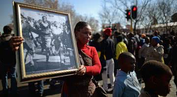 Mulher carrega foto do Levante de Soweto em marcha realizada em 2013 - Getty Images