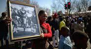 Mulher carrega foto do Levante de Soweto em marcha realizada em 2013 - Getty Images