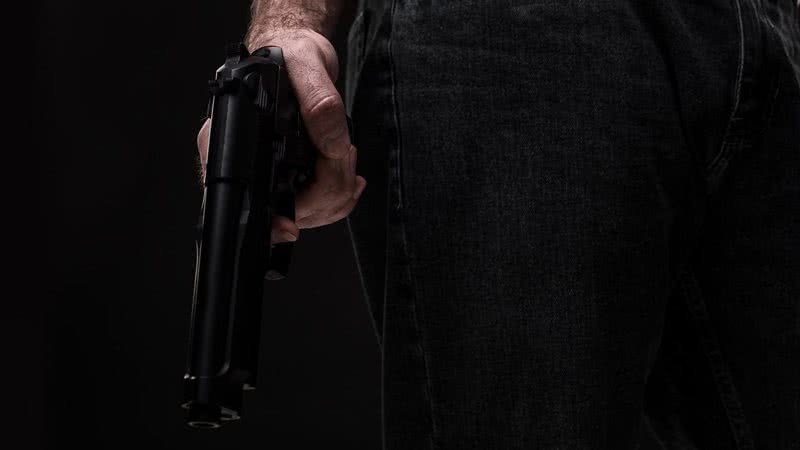 Imagem meramente ilustrativa de homem segurando arma - Divulgação/ Freepik/ YuliiaKa