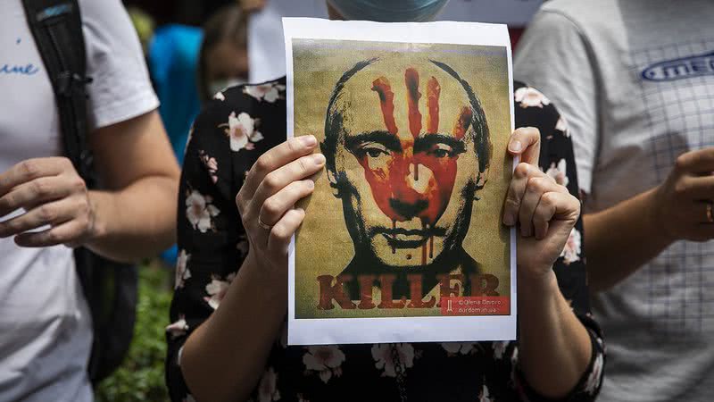 Ucranianos protestando com um cartaz contra Putin