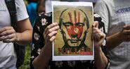 Ucranianos protestando com um cartaz contra Putin - Getty Images