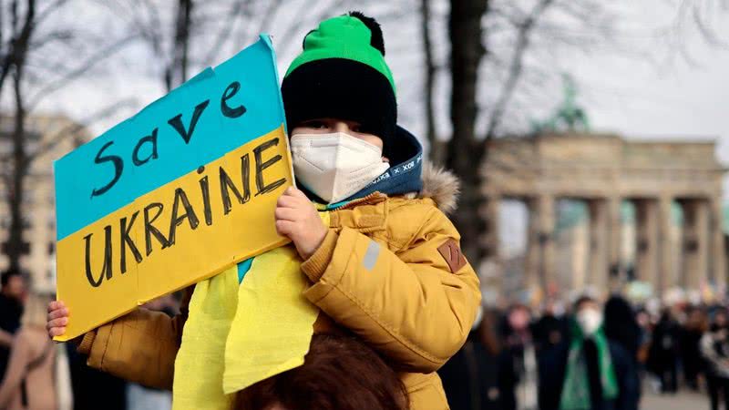 Criança mostra placa de apoio à Ucrânia em Berlim