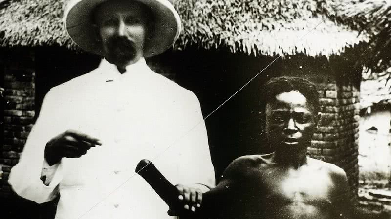 Um colonizador belga exibe congolês com a mão amputada - Wikimedia Commons