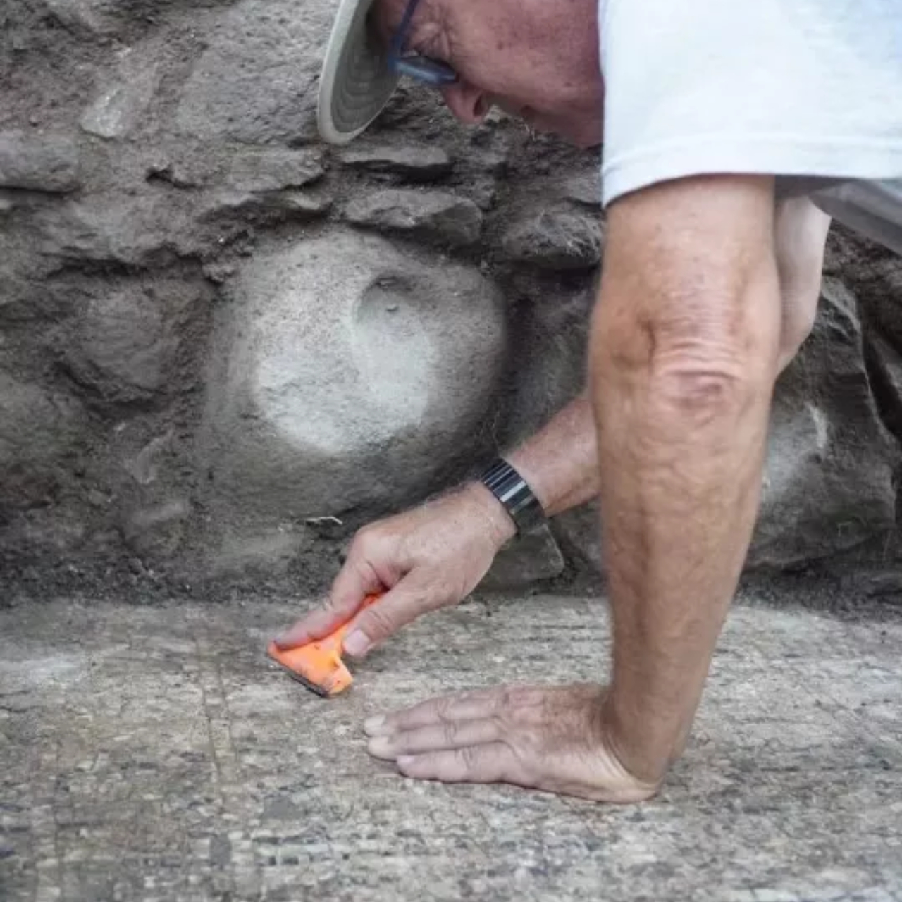 Arqueólogo limpando local onde foi feita descoberta de inscrições gregas