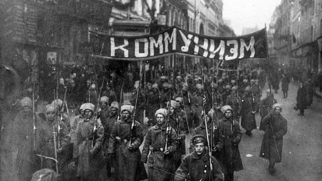 Soldados armados carregam uma bandeira que diz "Comunismo", em 1917