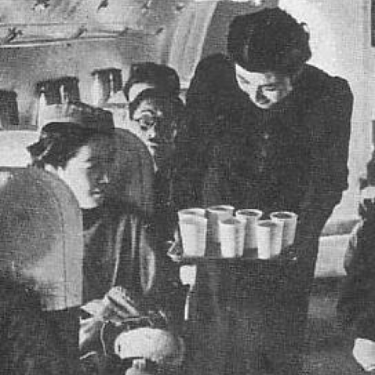 Comissária de bordo da Imperial Japanese Airways entregando bebidas a passageiros, por volta de 1940
