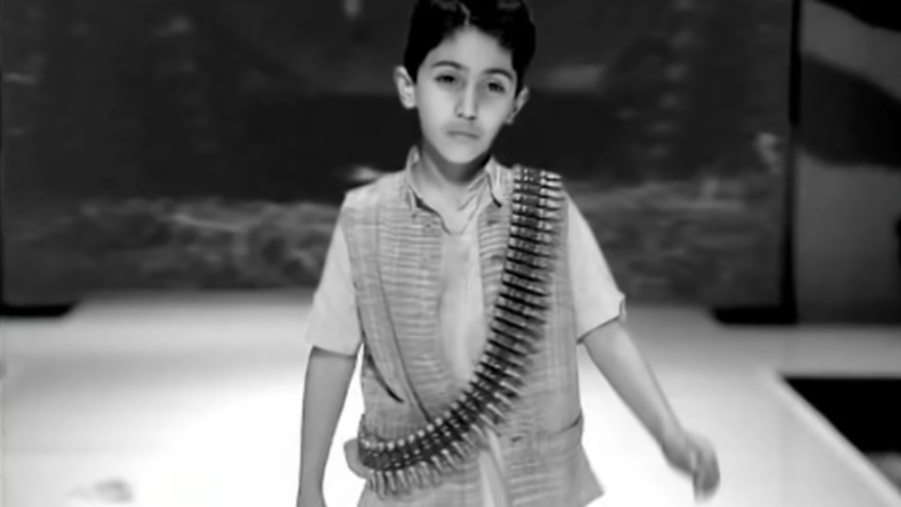 Imagem de momento do videoclipe de 'American Life' em que representa uma criança iraquiana com munições enroladas em seu corpo