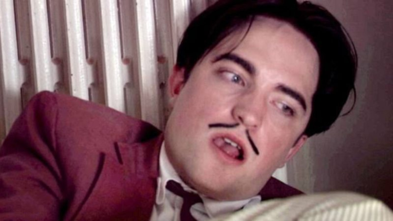 Close no rosto de Robert Pattinson, interpretando Salvador Dalí em 'Poucas Cinzas', durante cena de masturbação
