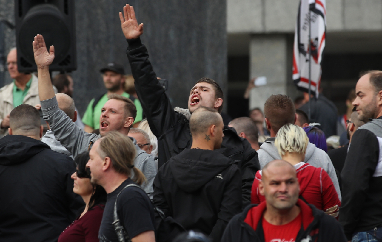 Dois homens levantando a mão em referência a saudação nazista, na Alemanha