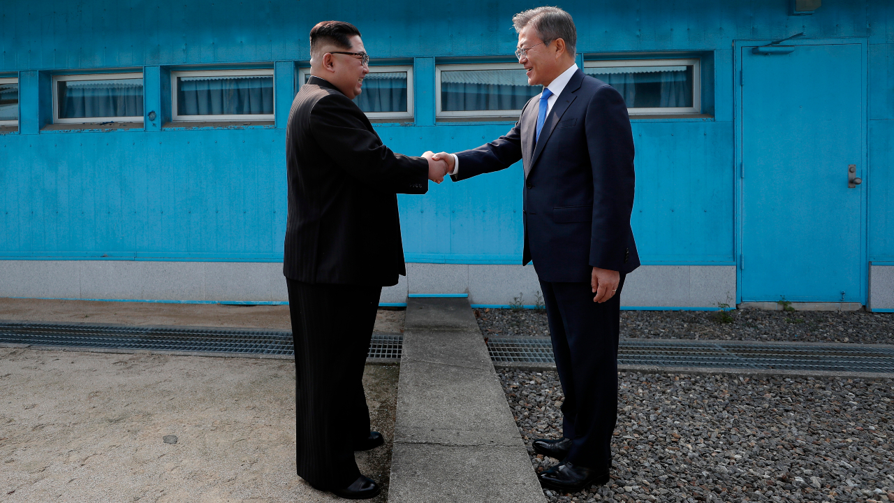 O líder supremo da Coreia do Norte, Kim Jong-un, e o ex-presidente da Coreia do Sul, Moon Jae-in, apertando as mãos da região fronteiriça de Panmunjom