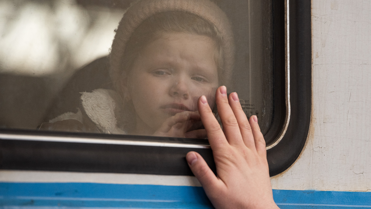 Criança ucraniana se despedindo de seu pai enquanto foge de conflito, em março de 2022